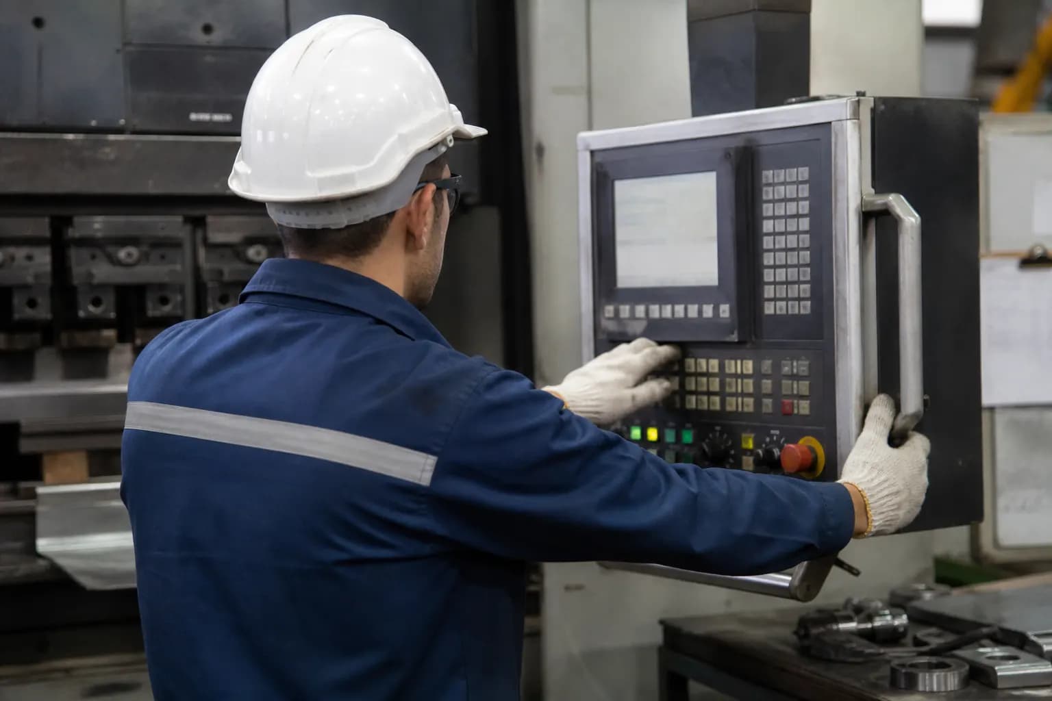 Operator running a fabrication machine from the control station